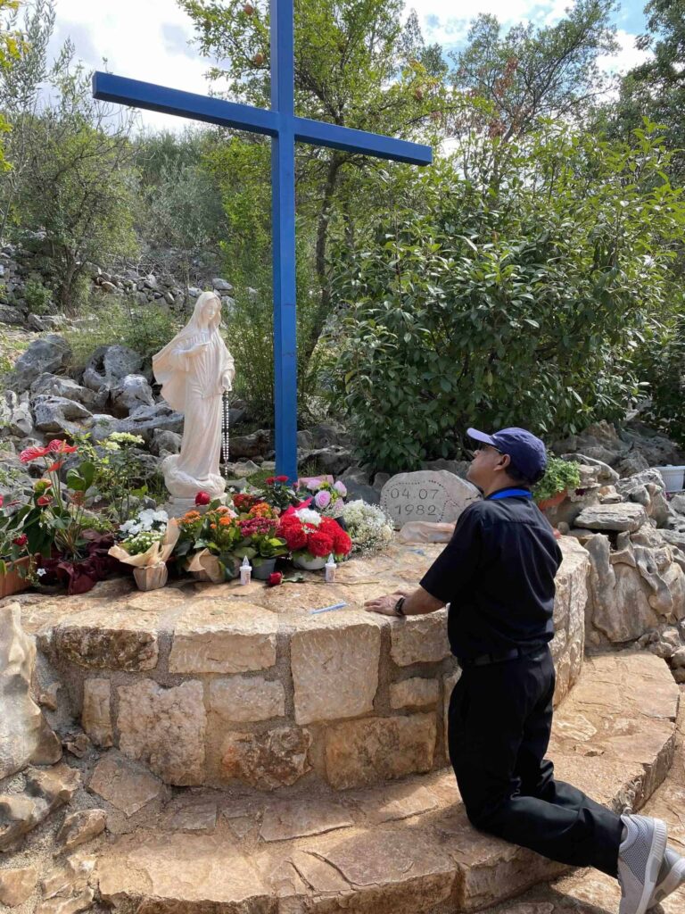 praying at the blue cross on Medjugorje pilgrimage