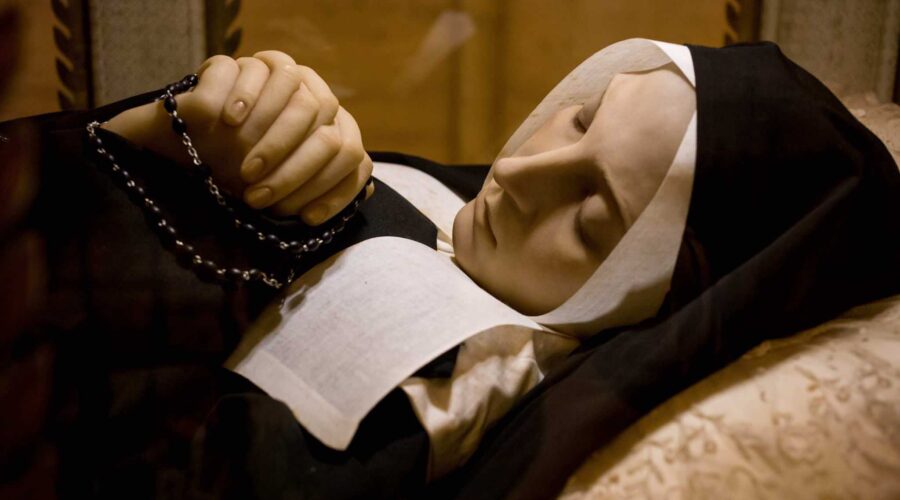 St Bernadette with rosary in repose at Lourdes pilgrimage tour