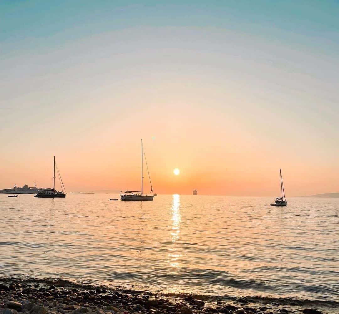 Mykonos sunset with sailboats greece pilgrimage tour