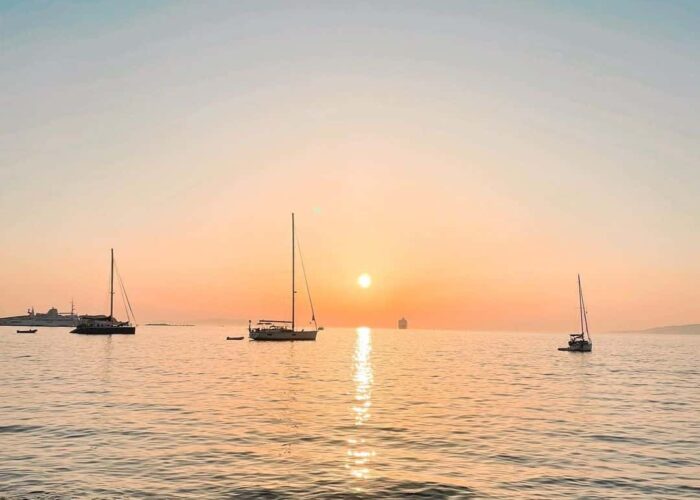 Mykonos sunset with sailboats greece pilgrimage tour