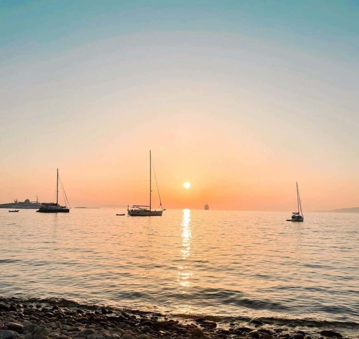 Mykonos sunset with sailboats greece pilgrimage tour