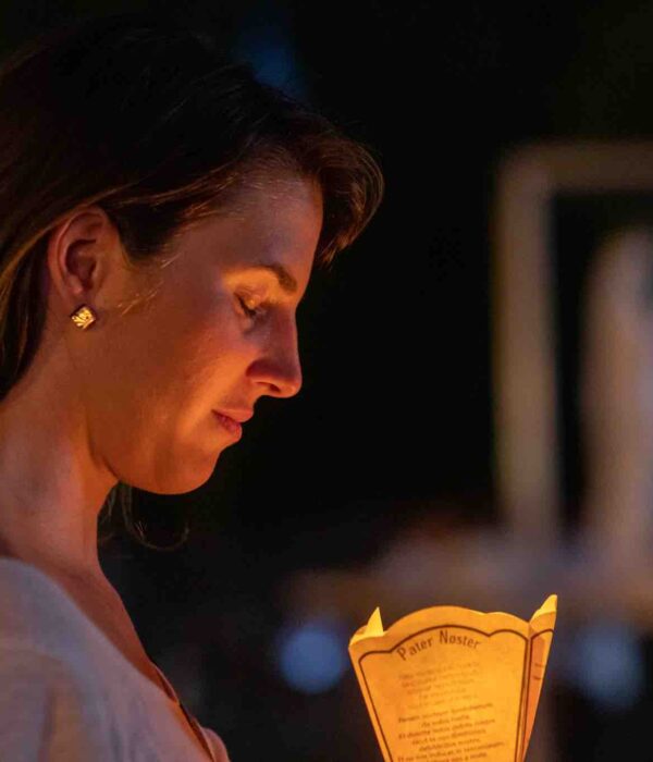 woman with candle at lourdes pilgrimage tour